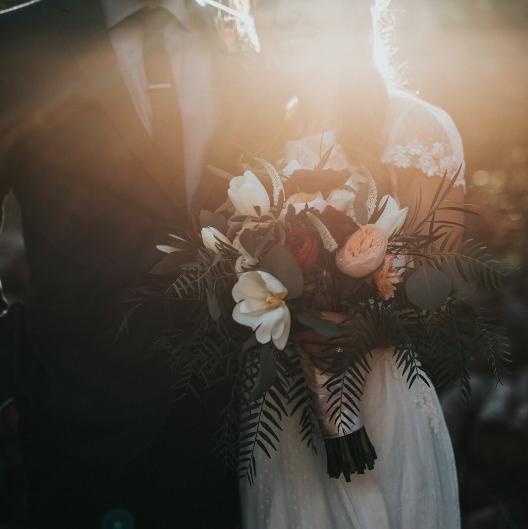 groom beside bride holding bouquet flowers